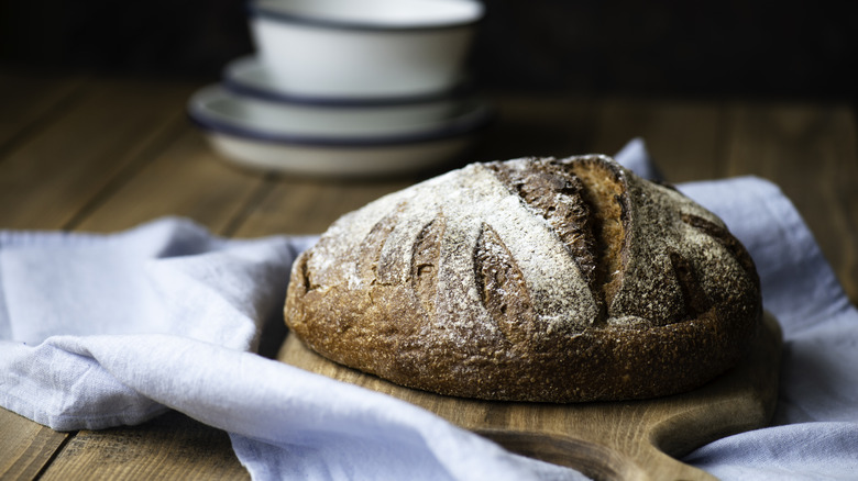 a loaf of brown bread on a cutting board