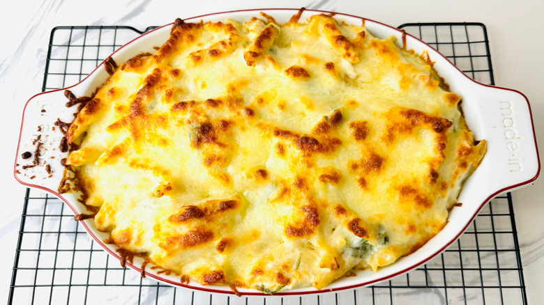 Baked cheese-topped pasta dish sitting on wire rack
