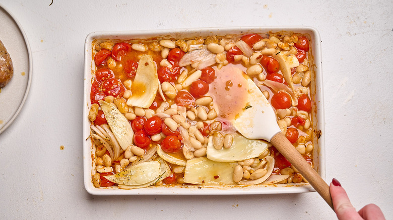 pressing beans and tomatoes with a spatula