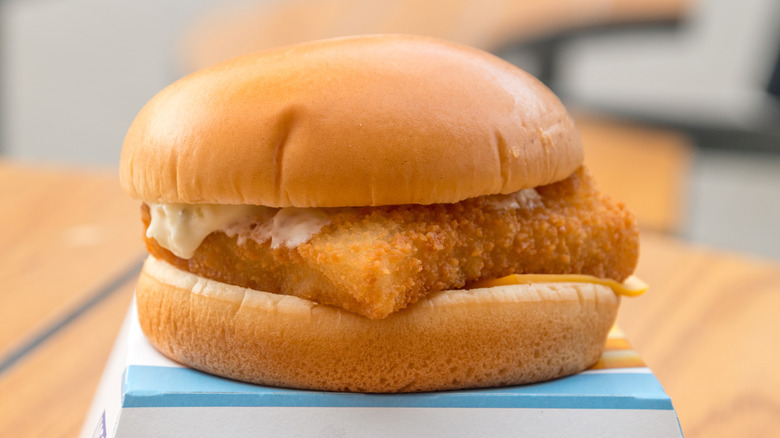 a Filet-O-Fish sandwich sitting atop its cardboard box