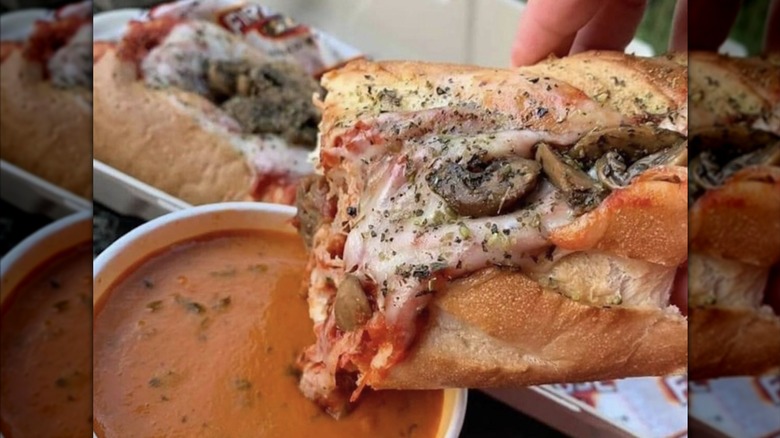 Sub dipped into bowl of chili.