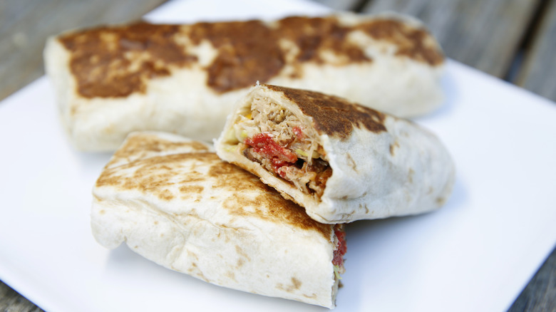 A grilled Taco Bell burrito on a white plate