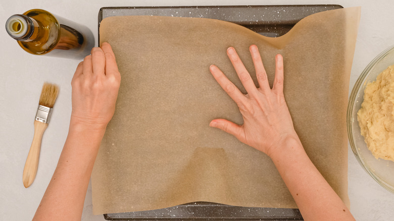 positioning parchment paper on tray