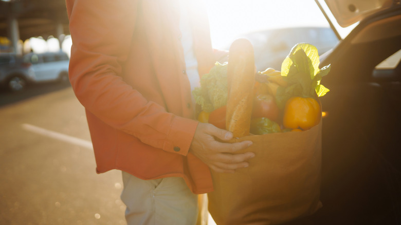 shopper carrying groceries to car