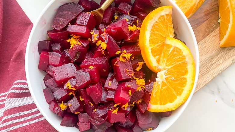 Beet cubes in bowl with orange zest and slices