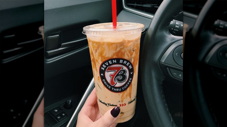 woman holding drink in car