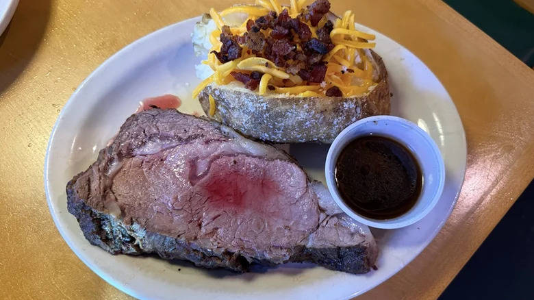 Prime rib from Texas Roadhouse beside baked potato