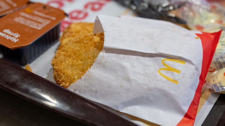 Close-up of a hash brown in a paper container on a tray at McDonald's