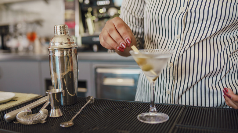 A woman making a martini at home