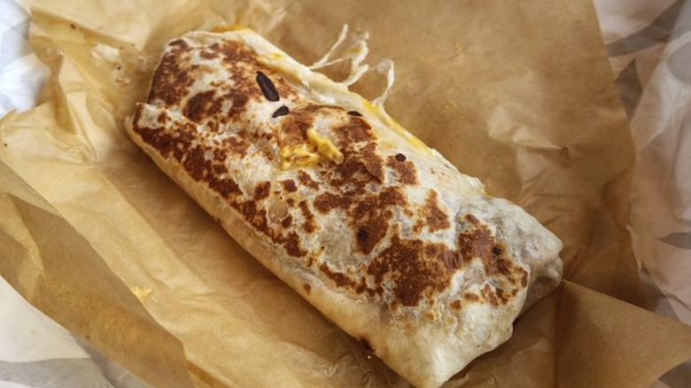 Taco Bell grilled burrito in open brown wrapper