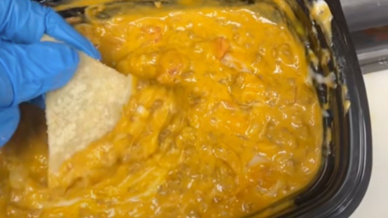 person dipping chip into Taco Bell Rotel dip dupe