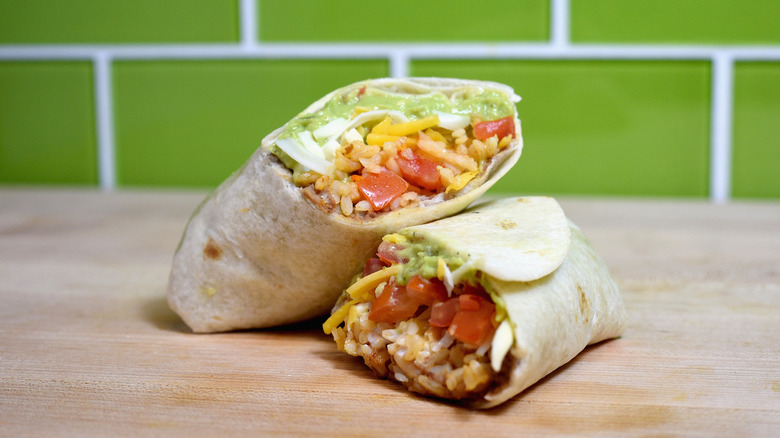 Taco Bell 7-Layer Burrito cut in half and stacked on wood