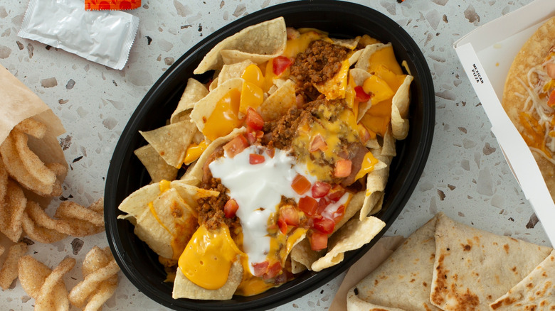 Taco Bell Nachos Bell Grande on table surrounded by menu items