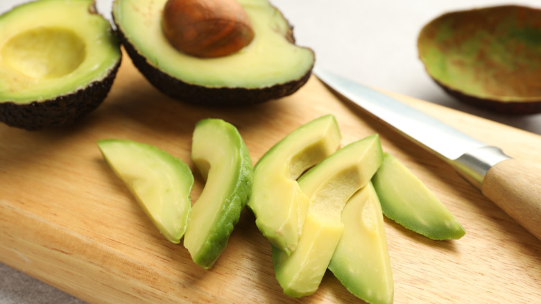 Avocado slices on a cutting board.