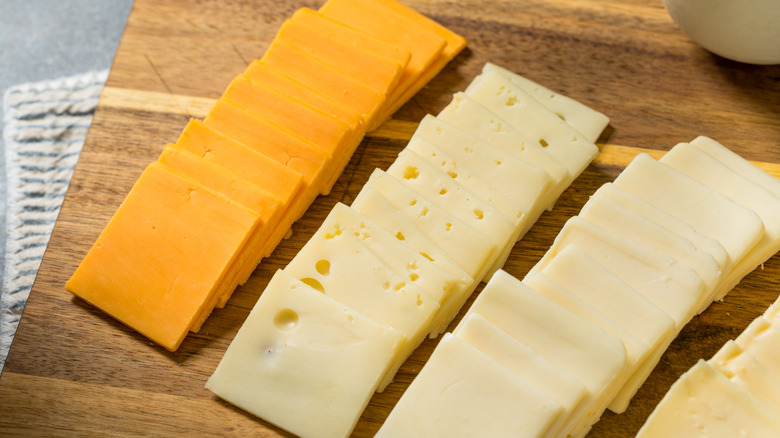 Slices of cheese on a cutting board.