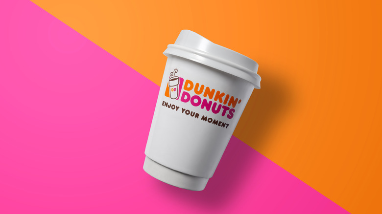 A Dunkin' Pumpkin Spiced Latte in front of pumpkins