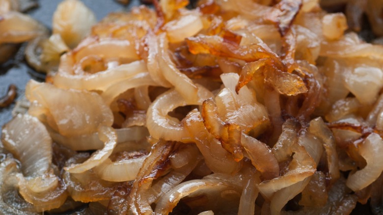 Some browned, fried onions in a pan.
