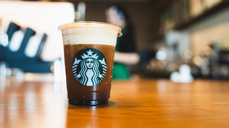 A grande-size Starbucks cold brew in a Starbucks plastic cup.
