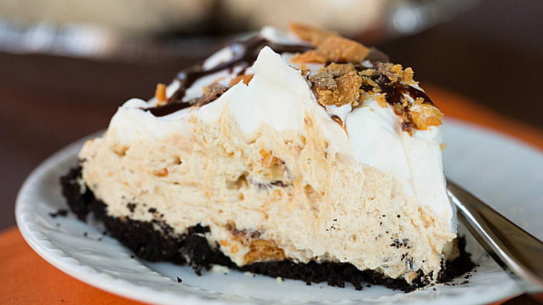 A slice of creamy whipped peanut butter pie on an Oreo base