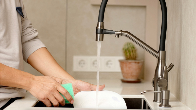 A sink being cleaned and tidied