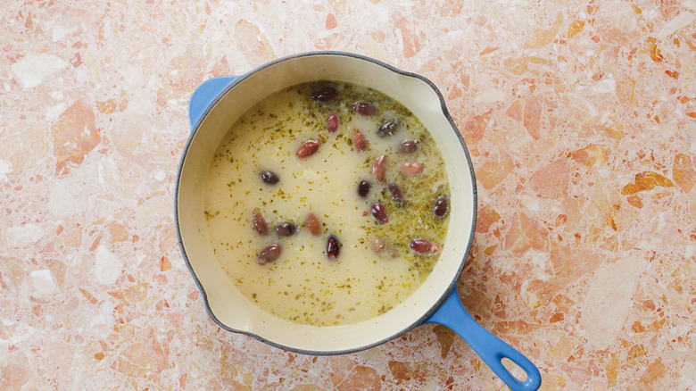 Dutch oven with chicken soup, orzo and olives