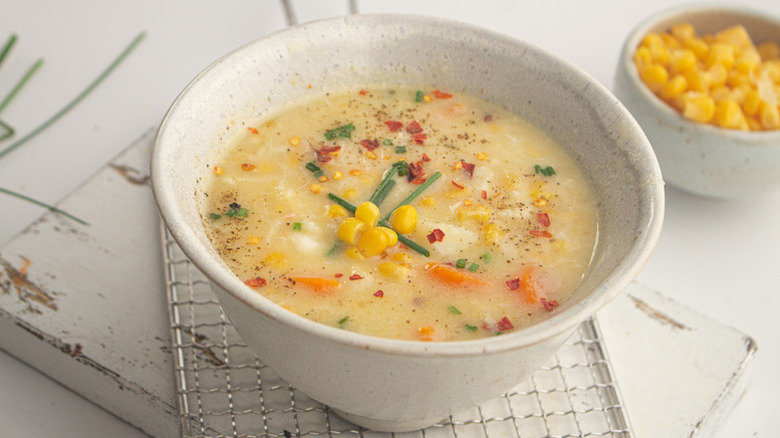 Bowl of crab and corn chowder with chopped chive garnish
