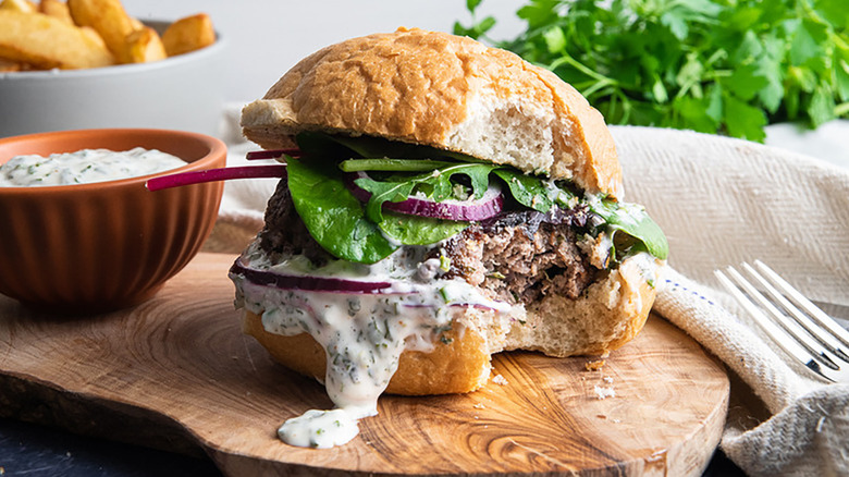 Lamb burger with red onion, greens, and tzatziki