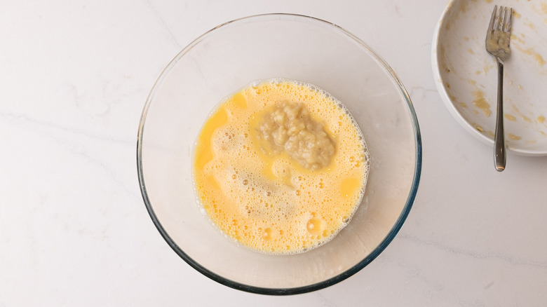 whisking mashed banana into eggs