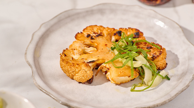 Chili crisp cauliflower steak and scallion salad on a plate