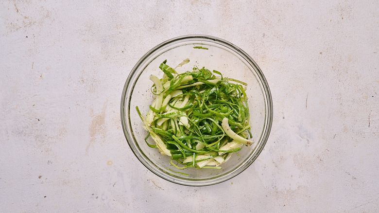 cauliflower leaves and scallions tossed in a bowl