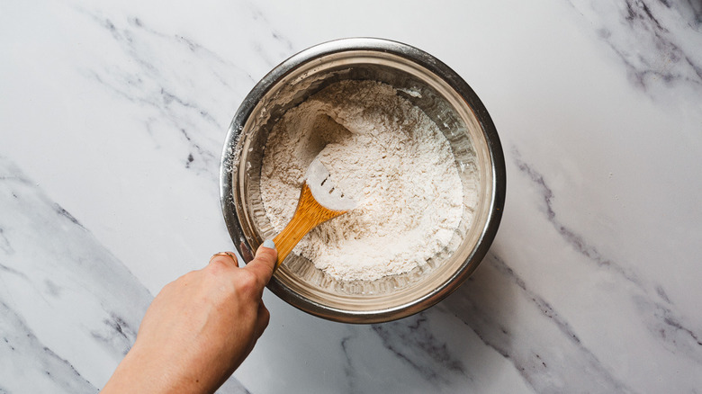 Mixing flour and honey with wooden spoon