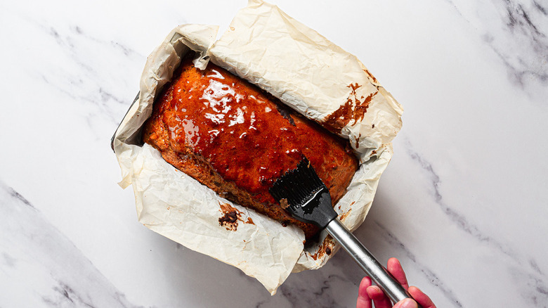 Brushing bread in pan with honey