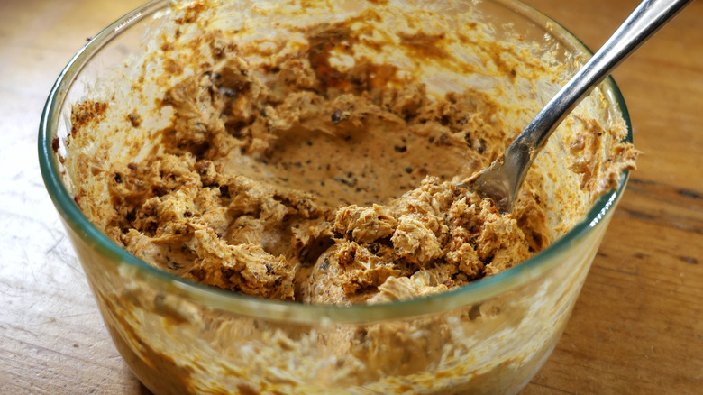 glass bowl of chorizo cream cheese mixture with spoon in it