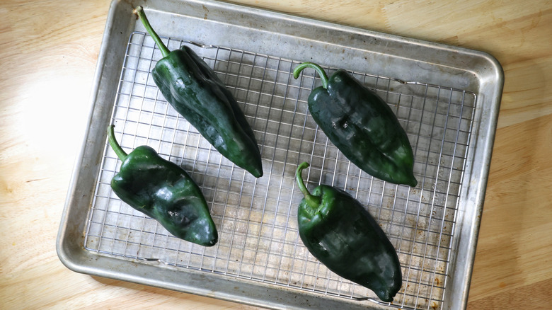 poblano peppers on a wire rack on a baking sheet