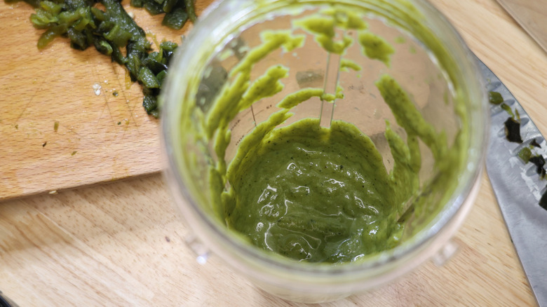 a blender container with roasted poblano puree in it