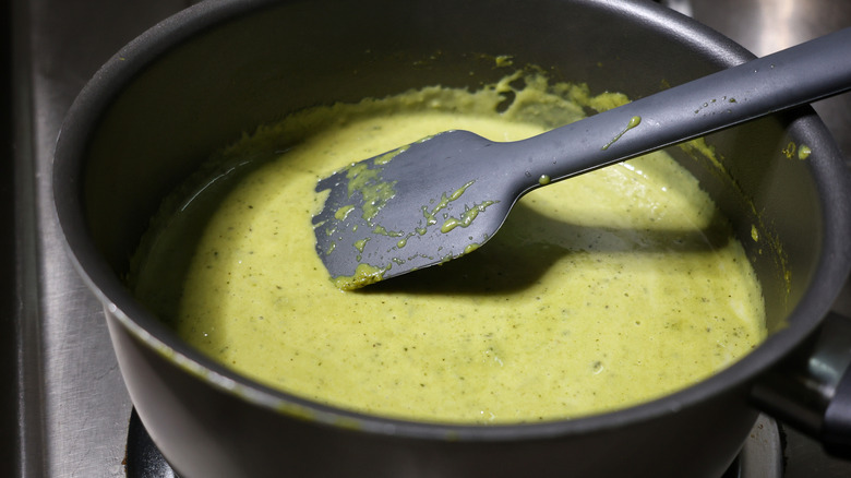 pot of poblano queso dip with silicone spatula in it