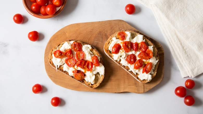 burrata toast with tomatoes on cutting board