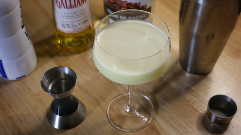 Golden Cadillac cocktail surrounded by shaker tools