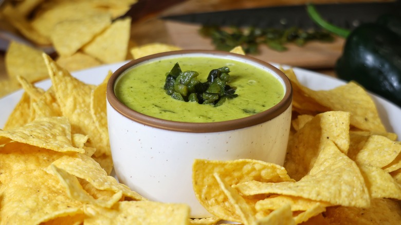 Green queso surrounded by tortilla chips