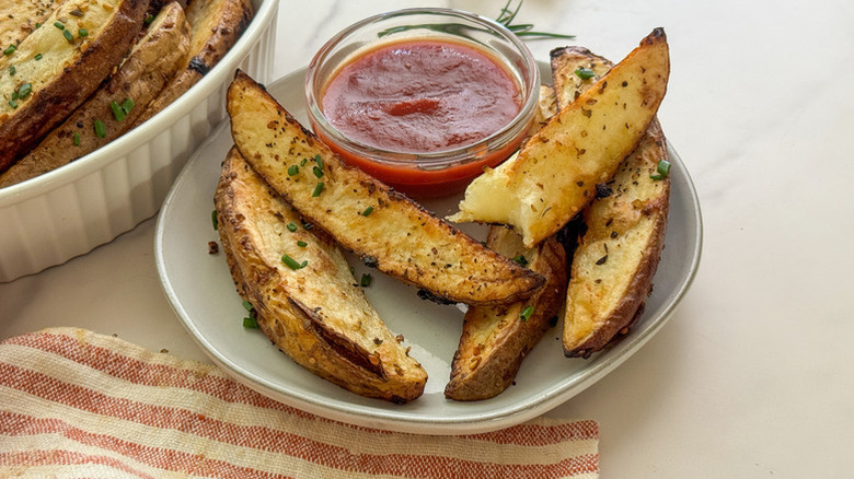 Potato wedges with ketchup on plate