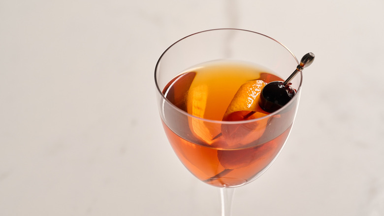 Rob Roy cocktail garnished with orange peel and cherry