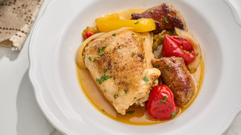 chicken thigh in broth in a bowl with peppers