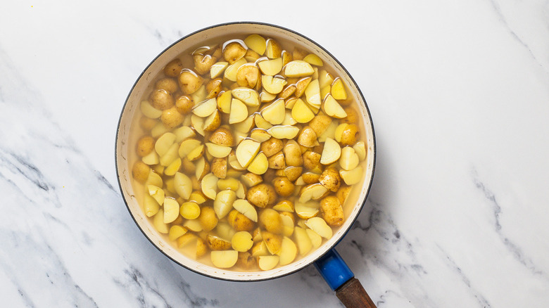 Boiled potatoes in pan.