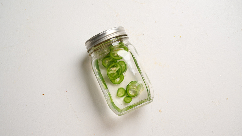 jalapenos and tequila in a mason jar