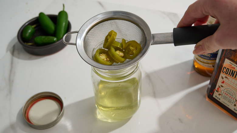 straining jalapeno out of the tequila