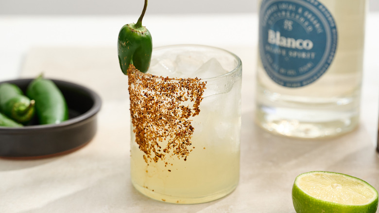 margarita garnished with a jalapeno on a table