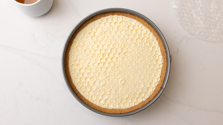 aerial view of set honeycomb pie in cake pan next to bubble wrap