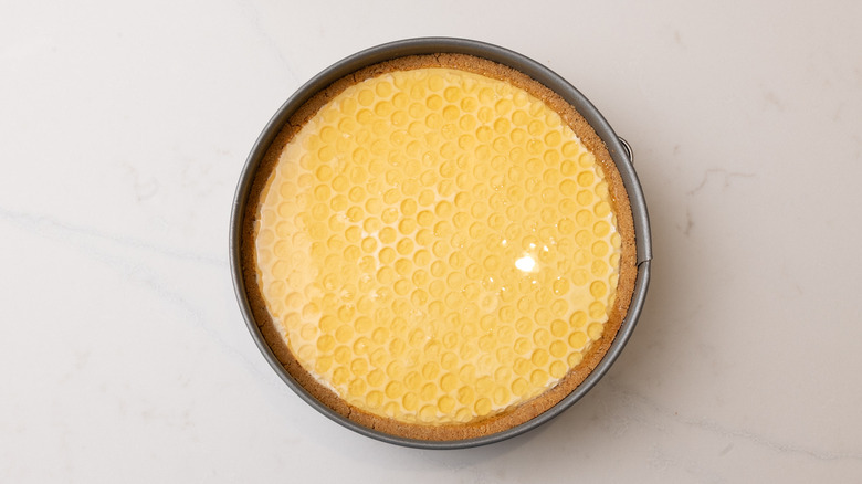 aerial view of honeycomb pie topped with syrup in cake pan