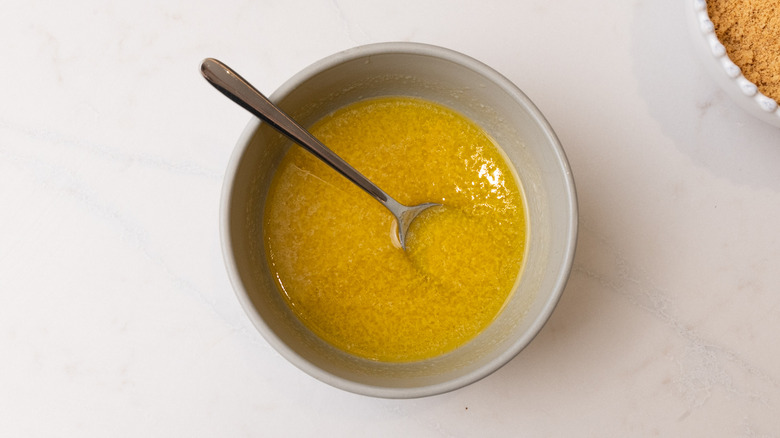 aerial view of melted honey and butter in a bowl with spoon inside