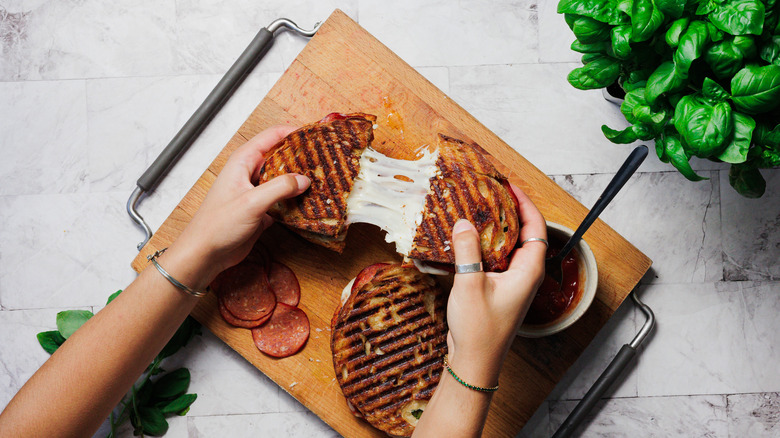 Pulling two pizza grilled cheese halves apart